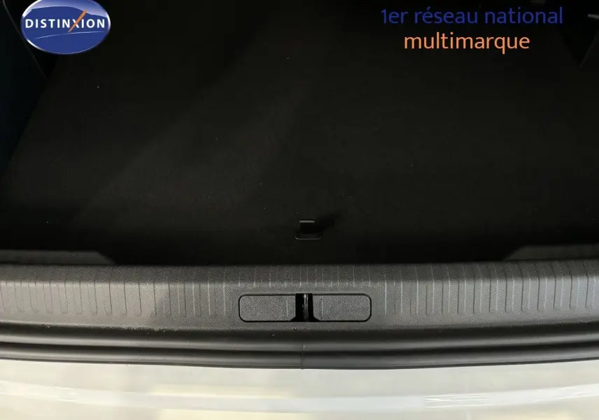 Vue rapprochée de l'ouverture du coffre d'une Citroën C4 blanche, montrant le seuil et l'intérieur noir du coffre.