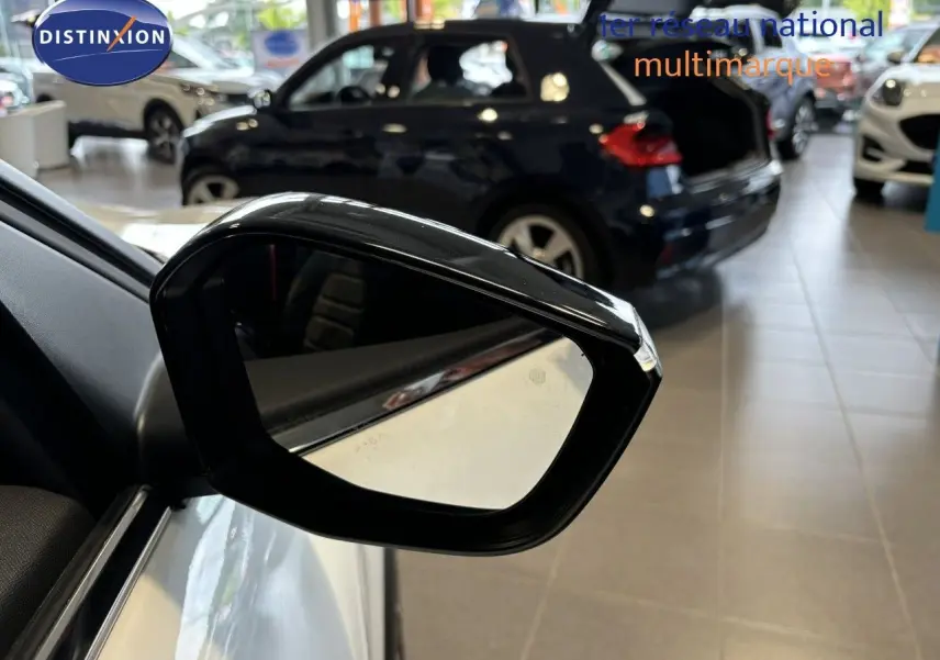 Rétroviseur extérieur noir du côté gauche d'une Citroën C4 blanche 2022 en showroom.