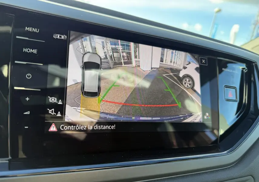 Écran tactile du système de navigation Discover Pro montrant la caméra de recul du Volkswagen Taigo bleu récif métallisé.