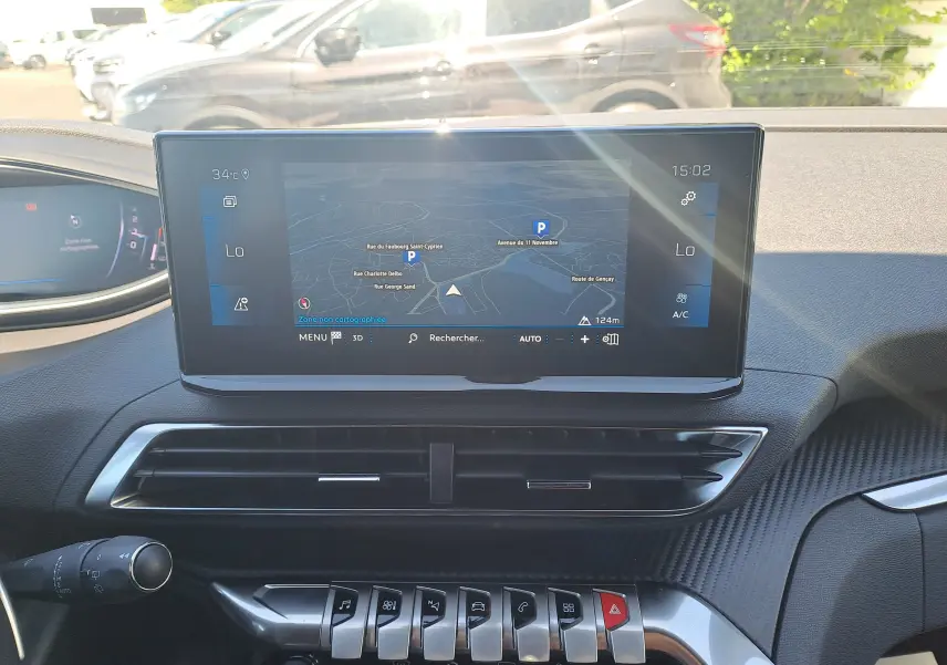 Vue intérieure du tableau de bord du Peugeot 3008 2023 avec écran tactile central affichant la navigation et commandes piano en métal.
