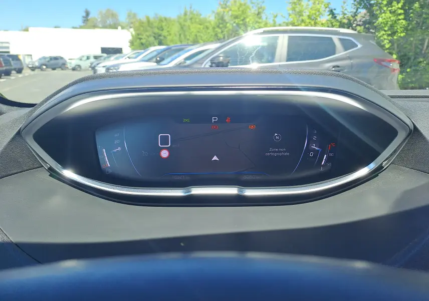 Vue rapprochée du tableau de bord numérique du Peugeot 3008 2023, affichant la vitesse à 0 km/h et la température moteur.