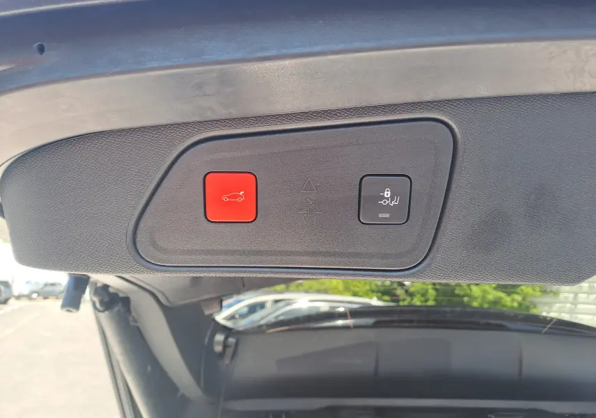 Gros plan sur les boutons d'ouverture et fermeture électrique du coffre du Peugeot 3008 blanc nacré, vue intérieure du hayon.