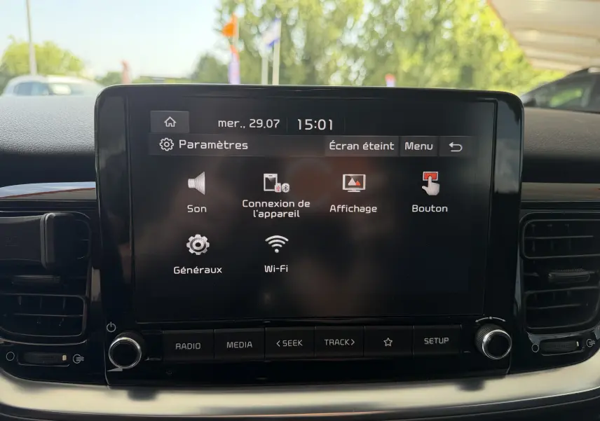 Écran tactile central de la Kia Stonic blanc 2023 affichant le menu des paramètres audio et connectivité.