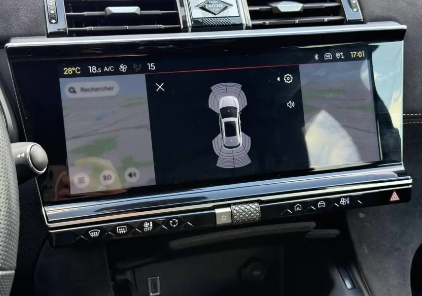 Vue rapprochée de l'écran tactile central du DS7 E-TENSE 2024 affichant l'aide au stationnement et la navigation.