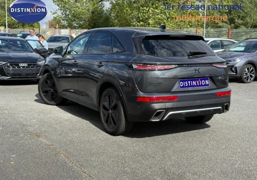 Vue 3/4 arrière droite du DS7 E-TENSE 225ch gris Titane avec jantes noires et feux arrière LED distinctifs.