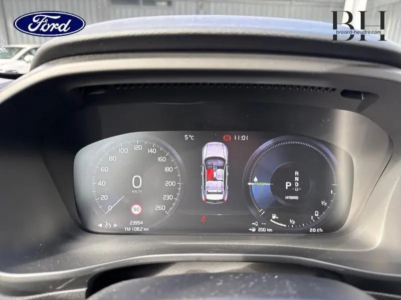 Tableau de bord numérique du Volvo XC40 T4 Recharge bleu Denim, affichant vitesse et mode hybride.