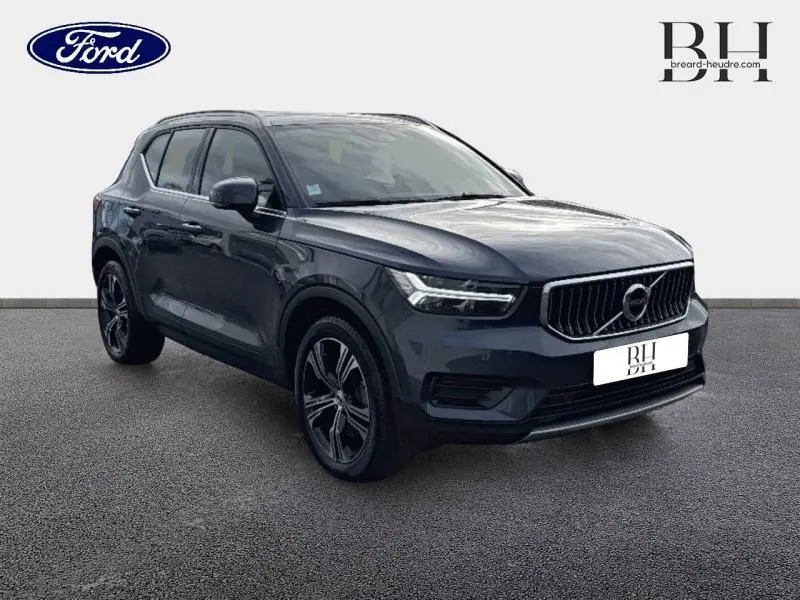 Volvo XC40 bleu Denim en vue 3/4 avant droit, avec calandre chromée et jantes alliage distinctives.