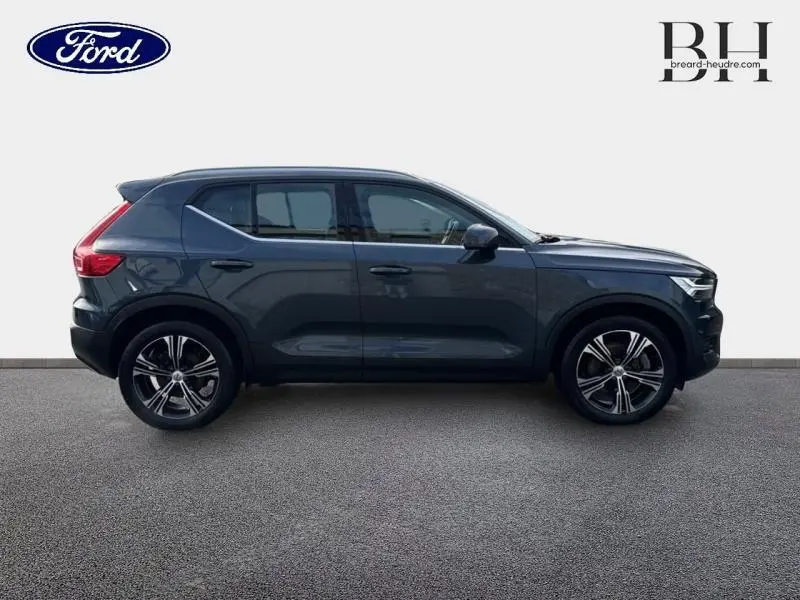 Vue de profil côté gauche du Volvo XC40 T4 Recharge bleu Denim avec jantes alliage et toit noir.