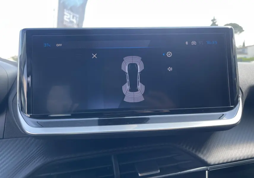 Écran tactile 10 pouces affichant l'aide au stationnement arrière dans le tableau de bord d'une Peugeot 208 noir Onyx.
