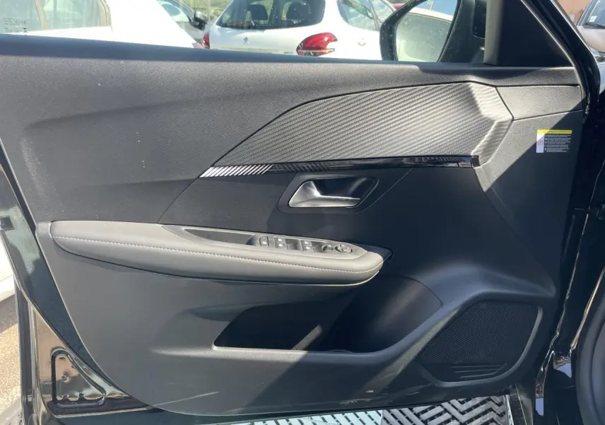 Porte avant gauche ouverte d'une Peugeot 208 noire Onyx, montrant les commandes électriques et le design texturé intérieur.
