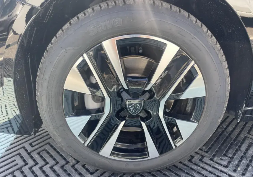 Gros plan sur la jante alliage 16'' NOMA diamantée biton noir et argent de la Peugeot 208 noir Onyx 2024.