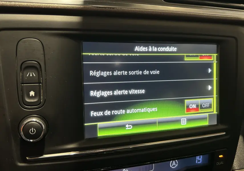 Écran tactile central du Renault Kadjar gris 2015 montrant les réglages d’aides à la conduite en intérieur.