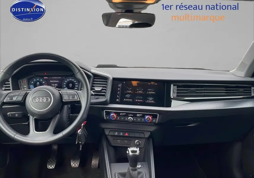 Intérieur de l'Audi A1 Sportback 30 TFSI 2022 vu de face, volant cuir sport et écran multifonction couleur.