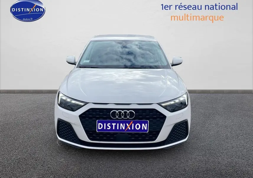 Vue de face d'une Audi A1 Sportback blanche 2022 avec calandre noire et phares LED allumés.