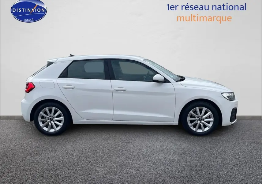 Profil latéral droit d'une Audi A1 Sportback blanche de 2022 avec jantes alu 16 pouces sur fond neutre.