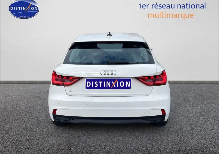 Vue arrière d'une Audi A1 Sportback blanche 2022 avec feux LED et logo distinctif sur fond neutre.
