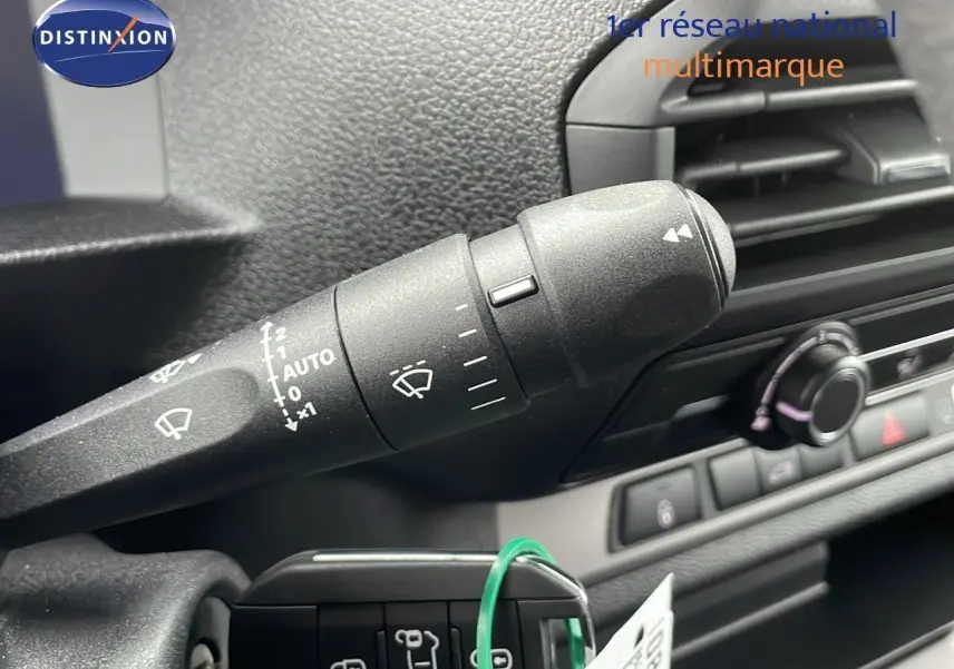 Gros plan sur la commande d’essuie-glace noire à l’intérieur du Peugeot Expert Fourgon blanc, tableau de bord en arrière-plan.