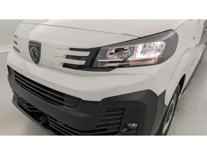 Vue rapprochée 3/4 avant droit du Peugeot Expert Fourgon blanc, mettant en valeur la calandre et les phares modernes.