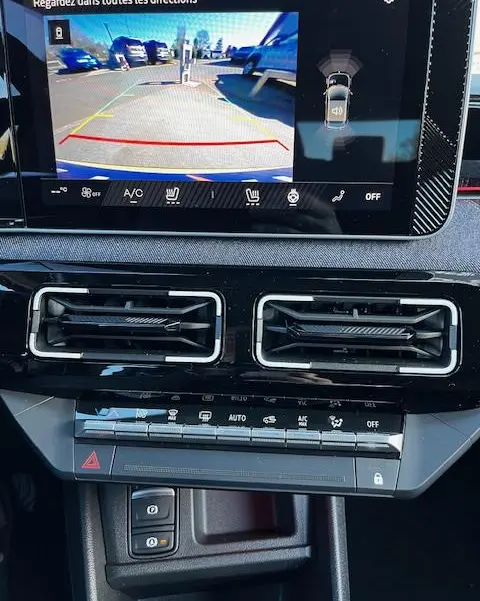 Vue intérieure du tableau de bord de la Renault R5 Techno 150 ch 2024 avec écran tactile affichant la caméra 360 et aérateurs centraux.