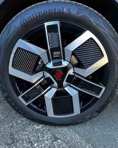 Gros plan sur la roue avant droite de la Renault R5 Techno jaune 2024 avec jante noire et argentée au design géométrique.