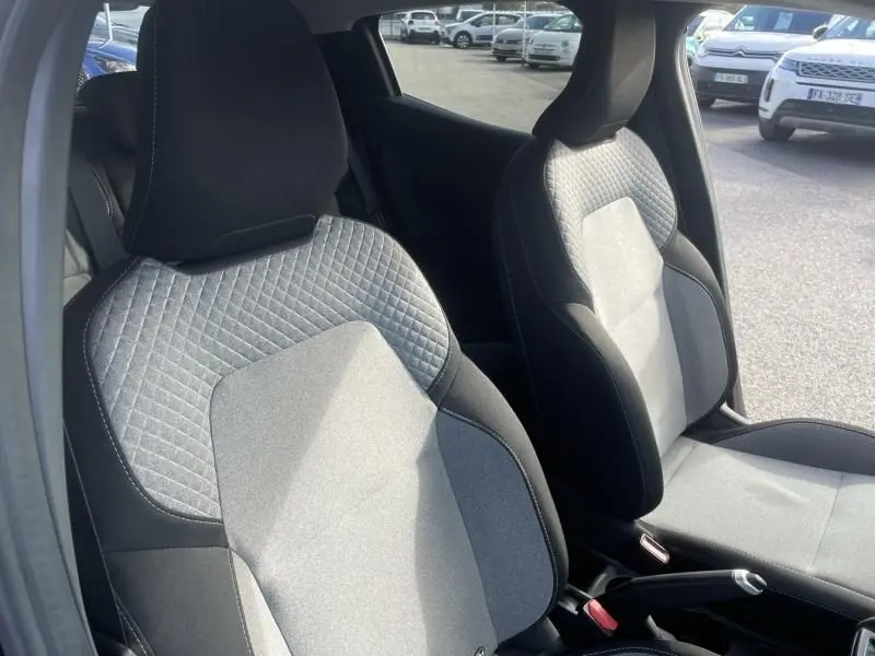 Vue intérieure des sièges avant gris et noir du Renault Clio V 1.5 DCI 100 Evolution noir, avec détails de couture apparents.