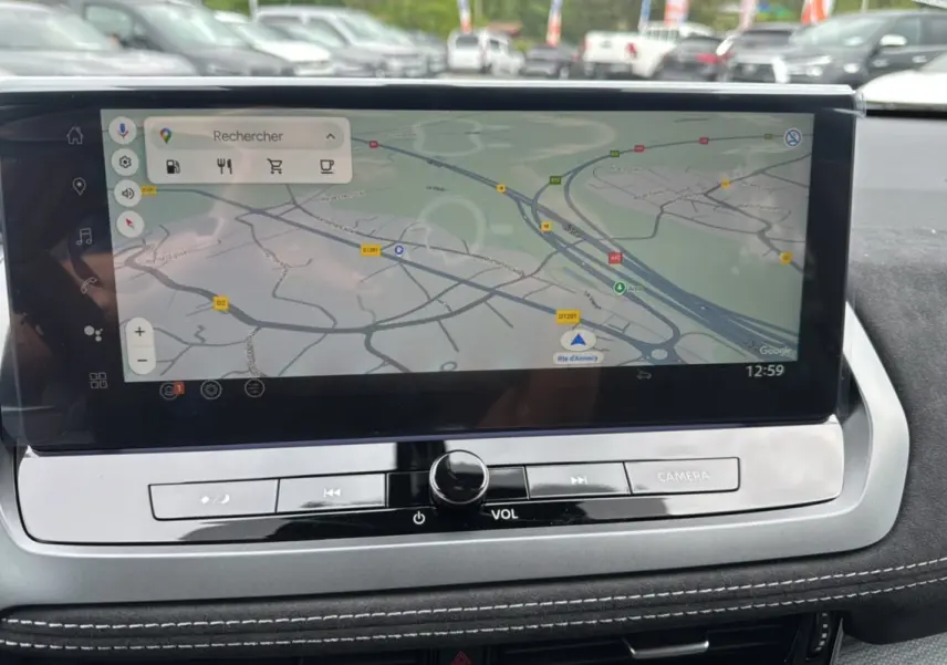 Écran tactile central du Nissan Qashqai E-POWER 205 Tekna Plus affichant une carte GPS, avec finition intérieure noire et surpiqûres blanches.