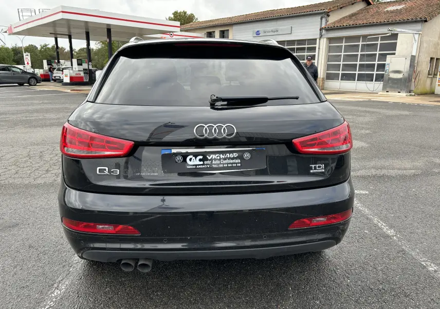 Vue arrière d'un Audi Q3 noir 2014 avec logo TDI et double sortie d'échappement visible sur parking.