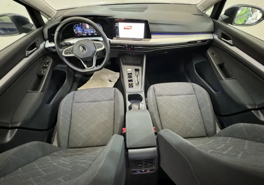 Vue intérieure avant de la Volkswagen Golf 2.0 TDI bleu, avec tableau de bord numérique et écran tactile central.