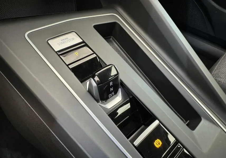 Gros plan sur la console centrale noire de la Volkswagen Golf 2021 avec levier de vitesse DSG et bouton start/stop.