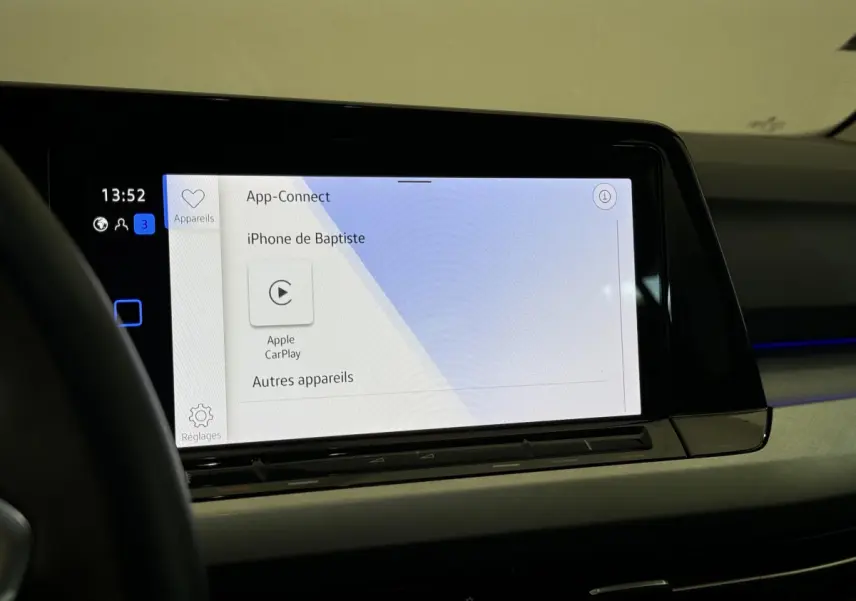 Écran tactile central affichant Apple CarPlay dans l'habitacle de la Volkswagen Golf bleu, vue intérieure côté conducteur.