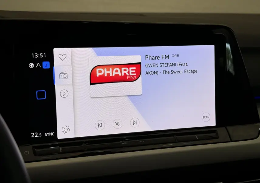 Écran tactile central affichant la radio Phare FM dans l'habitacle d'une Volkswagen Golf bleu 2021.
