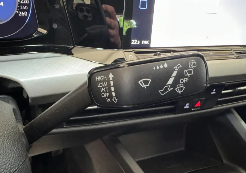 Gros plan sur la commande d'essuie-glace dans l'habitacle d'une Volkswagen Golf bleu 2021, avec tableau de bord numérique.