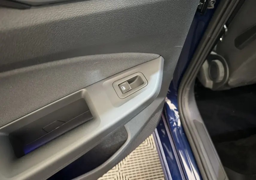 Gros plan sur la commande de lève-vitre de la porte avant gauche d'une Volkswagen Golf bleu 2021.