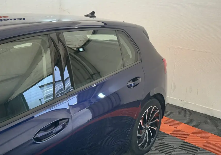 Vue latérale arrière droite d'une Volkswagen Golf 2.0 TDI bleu métallisé avec jantes alliage sport.
