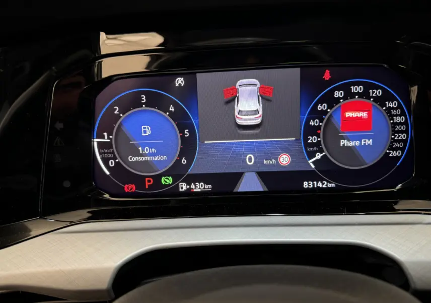 Affichage numérique du tableau de bord de la Volkswagen Golf bleu 2021 montrant consommation, vitesse et portes ouvertes.