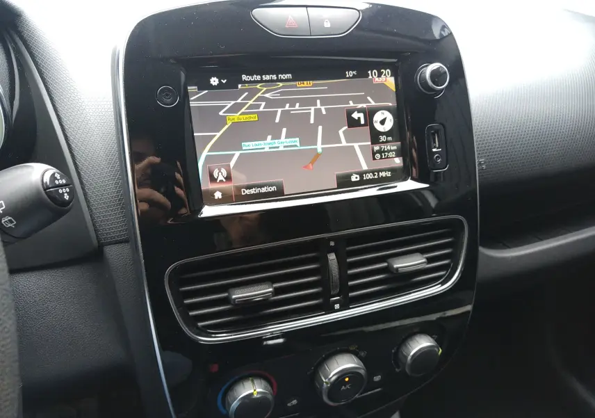 Vue rapprochée de la console centrale noire de la Renault Clio IV Société avec écran GPS et commandes de climatisation.