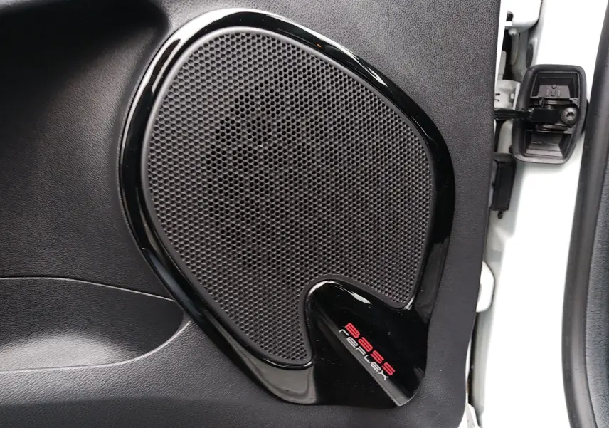 Gros plan sur l'enceinte de porte noire intégrée à la portière côté droit d'une Renault Clio IV Société blanche.