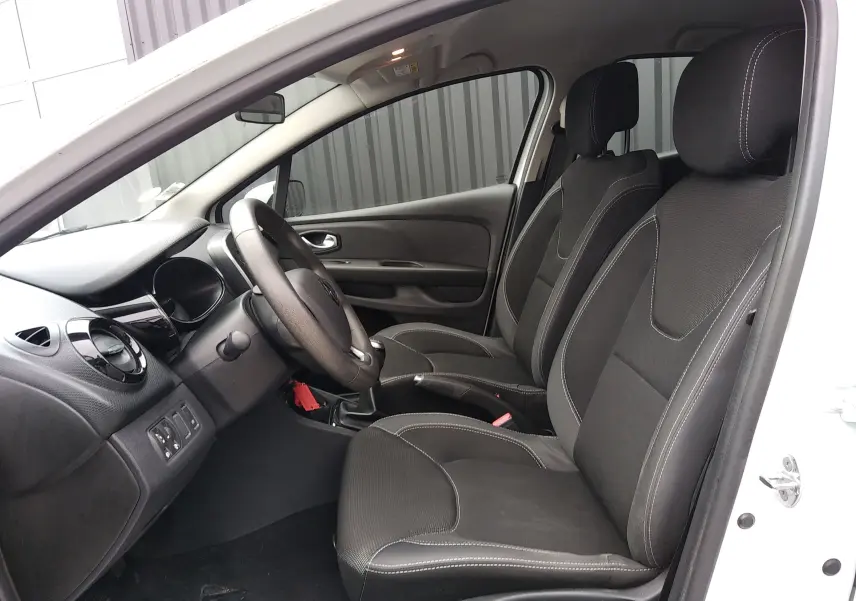 Intérieur côté conducteur d'une Renault Clio IV Société blanche, sièges tissu noir avec surpiqûres blanches visibles.