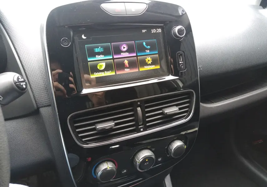 Tableau de bord noir brillant de Renault Clio IV Société 2019 avec écran tactile et commandes de climatisation visibles.