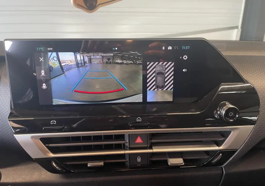 Écran central tactile de la Citroën C4 2025 blanc métallisé montrant la caméra de recul et l’aide au stationnement.