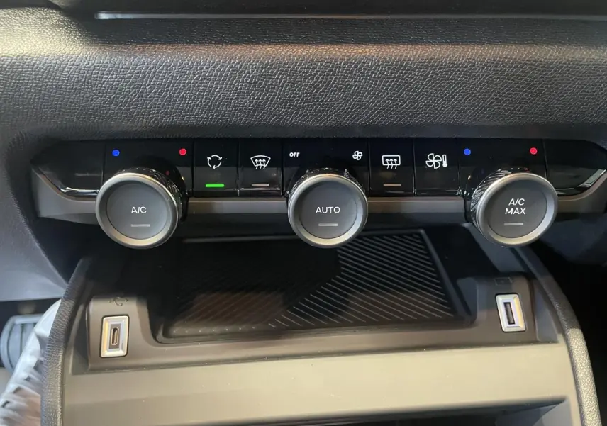 Vue rapprochée de la console centrale avec commandes de climatisation automatique bi-zone et prises USB dans une Citroën C4 blanche.