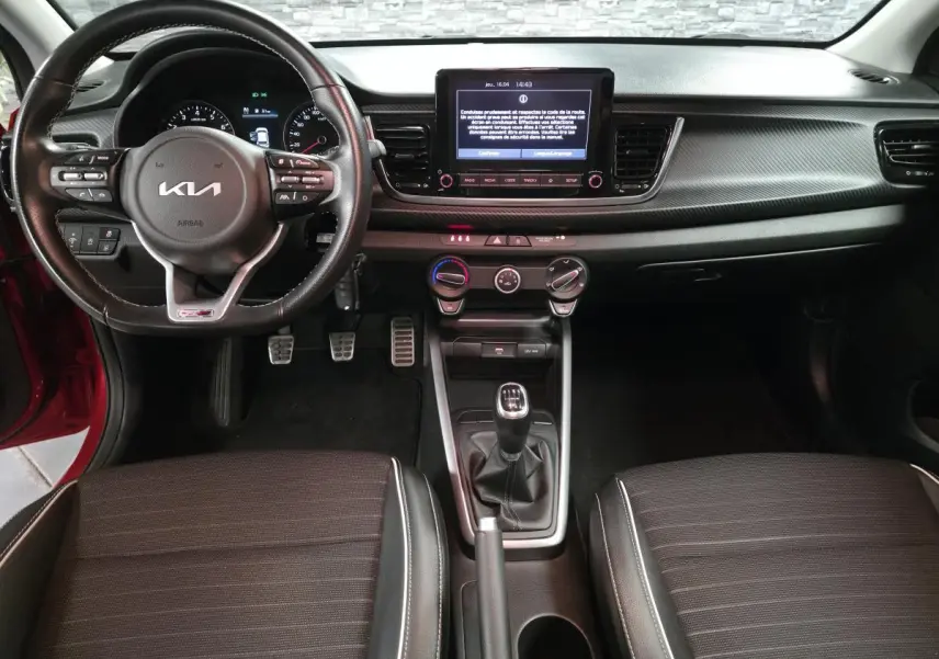 Vue intérieure avant de la Kia Rio GT Line 2022, volant cuir GT, écran tactile 8 pouces et levier de vitesses manuel.