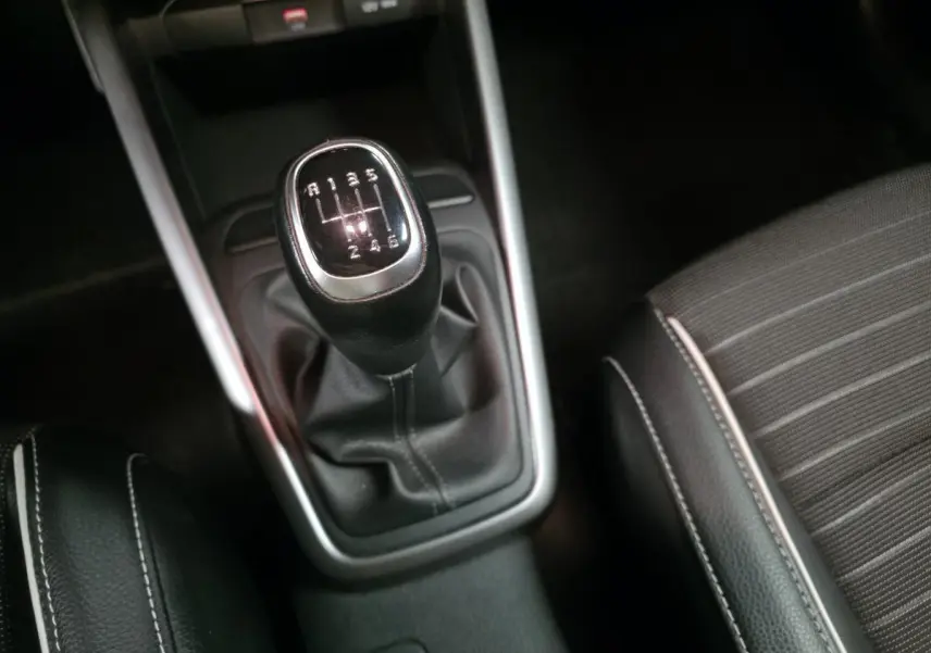 Levier de vitesses manuel noir avec surpiqûres blanches sur la console centrale d'une Kia Rio GT Line 2022.