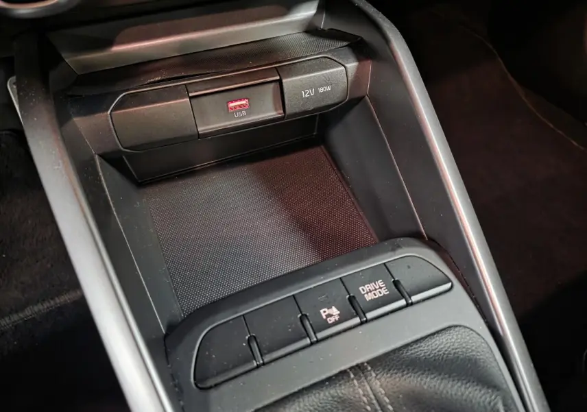 Gros plan sur la console centrale noire de la KIA RIO GT Line 2022, avec ports USB et bouton Drive Mode.