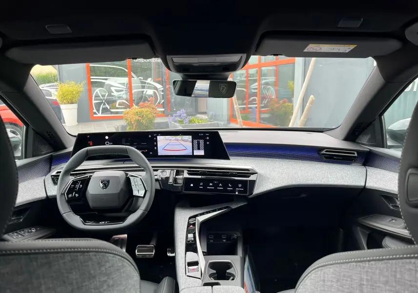 Vue intérieure avant du Peugeot 3008 Nouveau gris titane, avec tableau de bord numérique et volant compact noir.