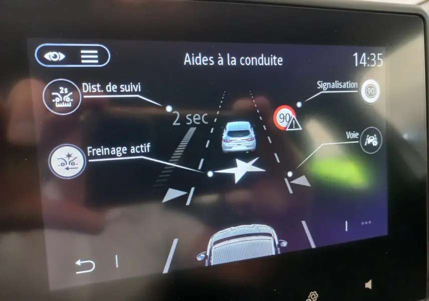 Écran tactile de la Renault Clio Business blanc montrant l'aide à la conduite avec freinage actif et suivi de distance.