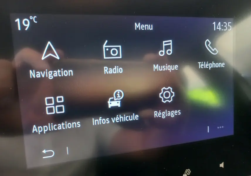 Écran tactile central de la Renault Clio Business blanc 2021 affichant le menu principal avec navigation et musique.