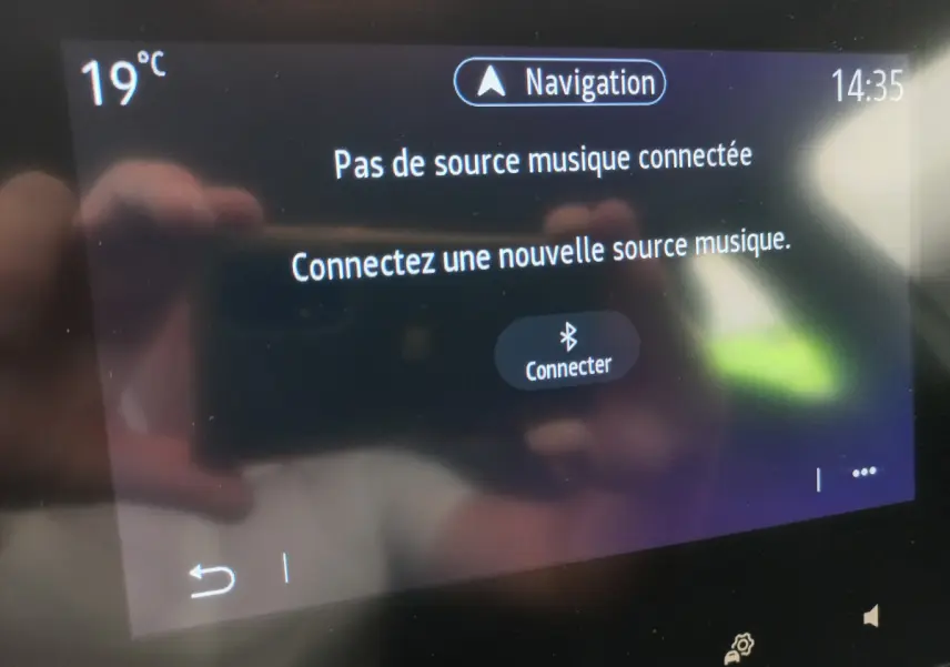 Écran tactile central de la Renault Clio Business blanc 2021 affichant un message de connexion Bluetooth pour la musique.