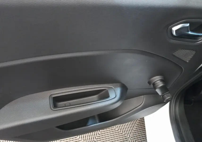 Détail de la porte intérieure côté droit de la Renault Clio Business blanche avec manivelle de vitre manuelle.