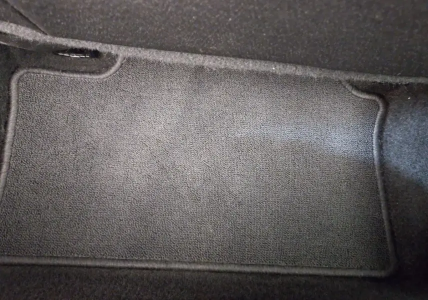 Tapis de sol noir en gros plan à l'intérieur d'une Renault Clio Business blanche 2021.